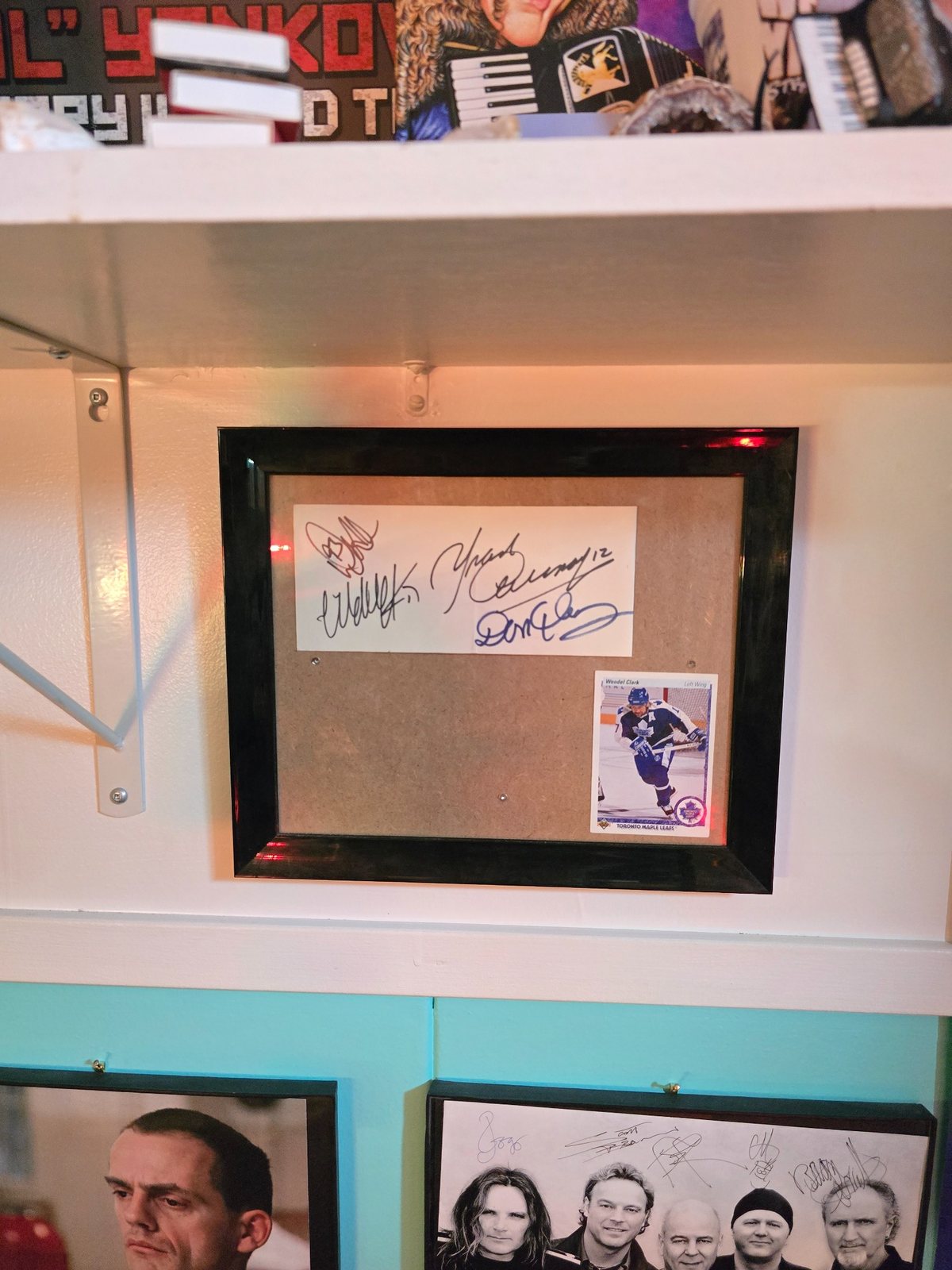 Framed hockey autograph display sitting on a white shelf among other collection items.