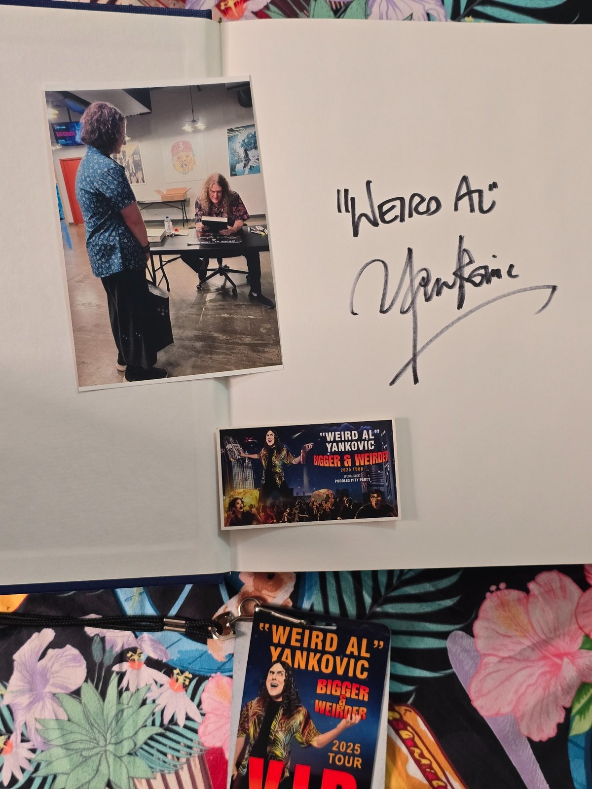 Open bound dissertation showing a handwritten Weird Al signature, with concert memorabilia and signing photos arranged around the page.
