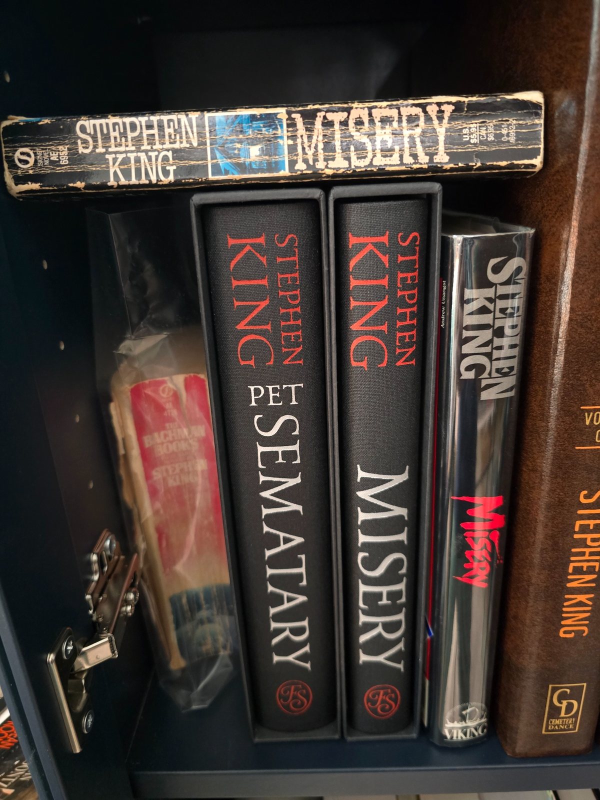 Stephen King books on a shelf, including Misery, Pet Sematary, and Cemetery Dance editions.