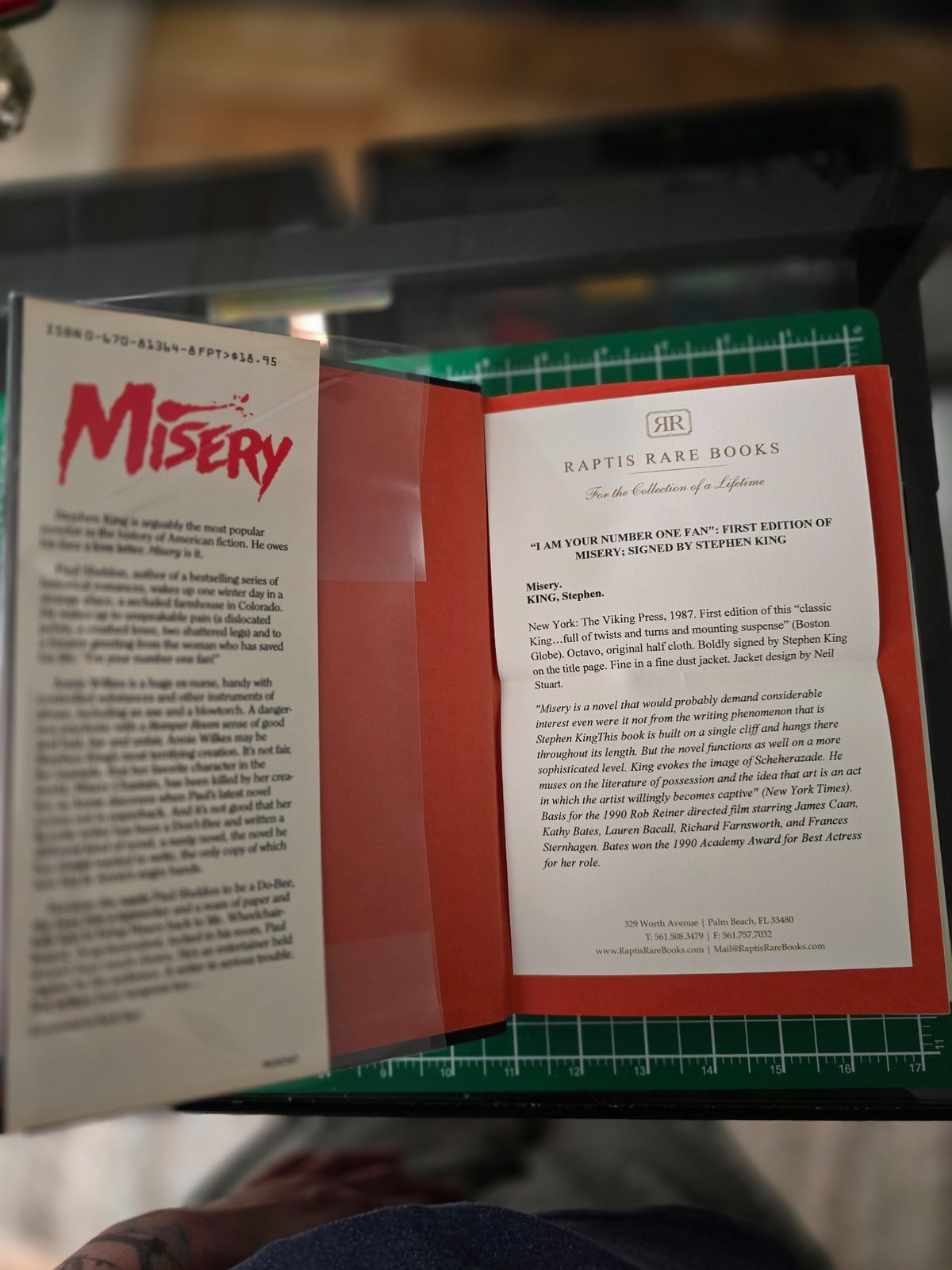 Open copy of Misery with a Raptis Rare Books document placed inside the book.